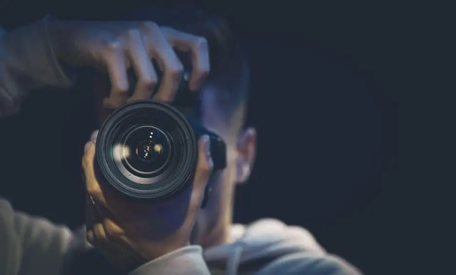 Man holding camera toward lens